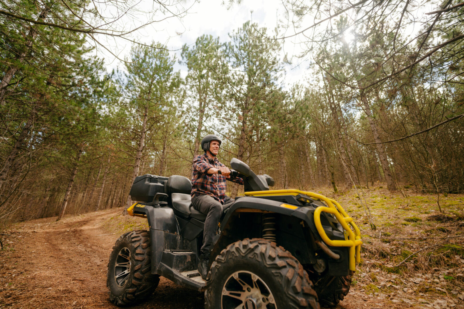 Person riding ATV through forest trail