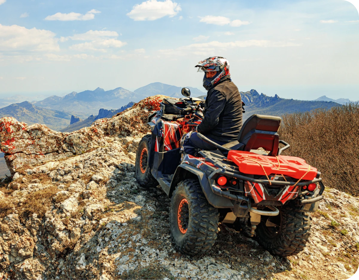 Person riding ATV on rocky mountain