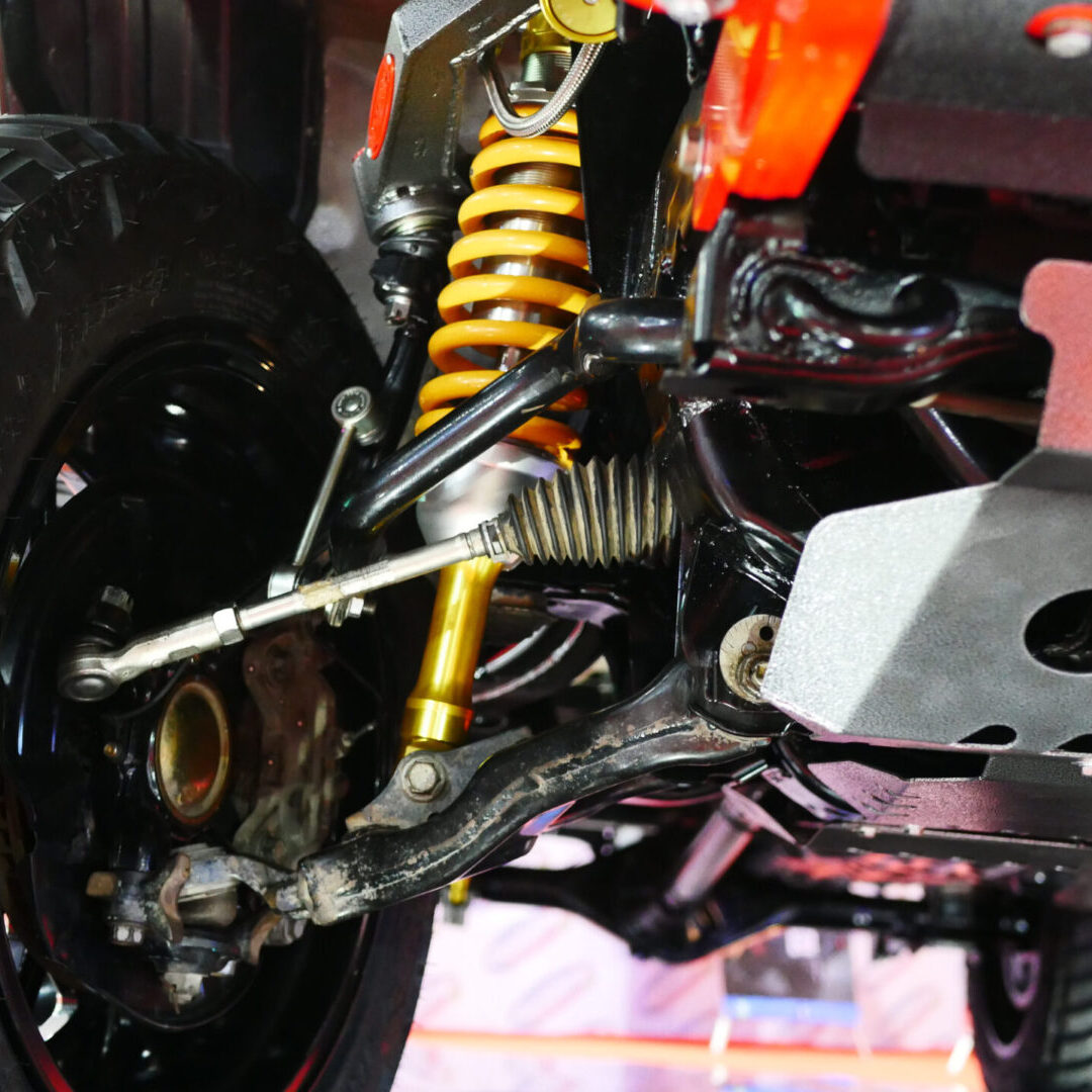 Close-up of a vehicle suspension system with coil spring and shock absorber.